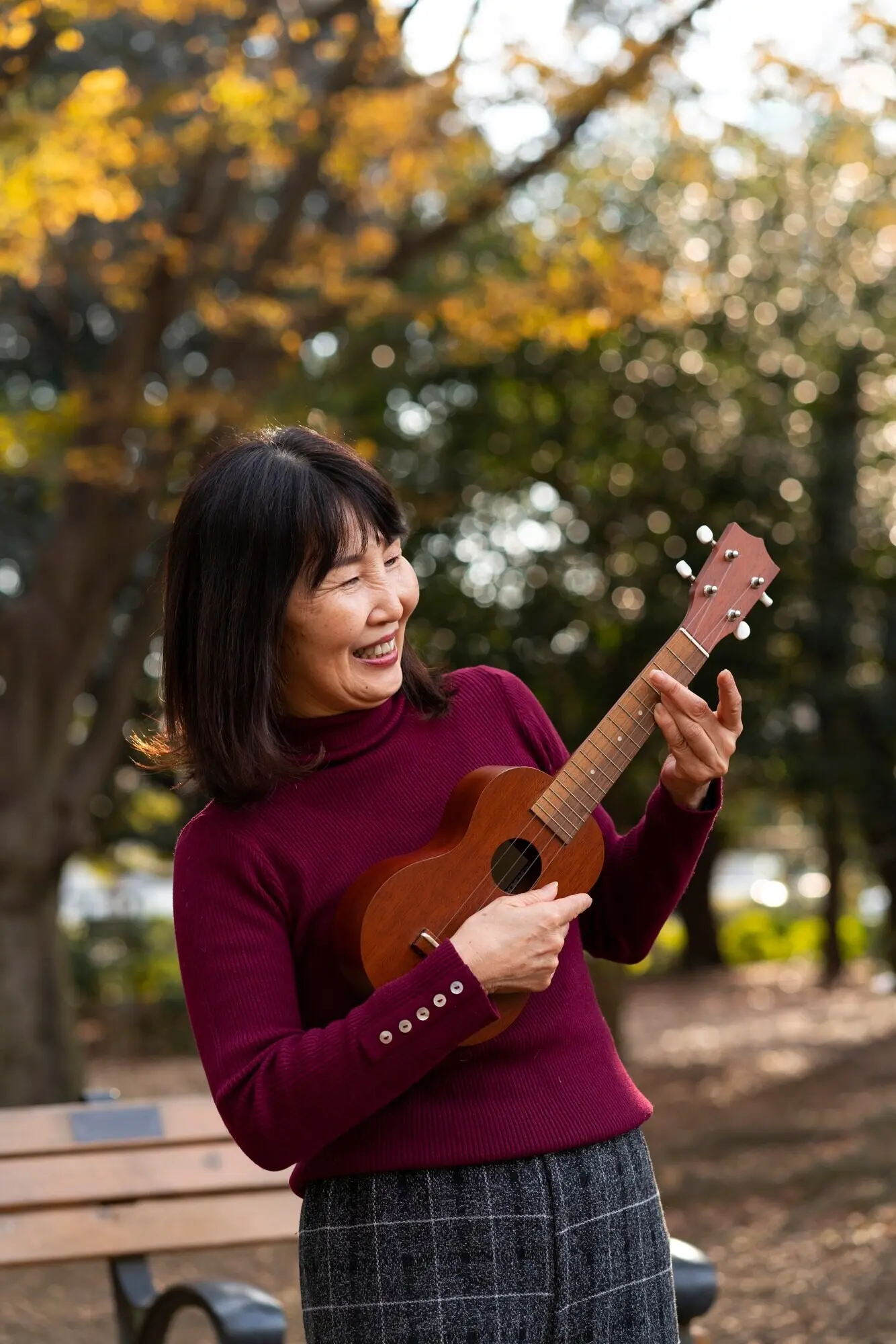 Mittlere Einstellung einer Frau, die Ukulele spielt.